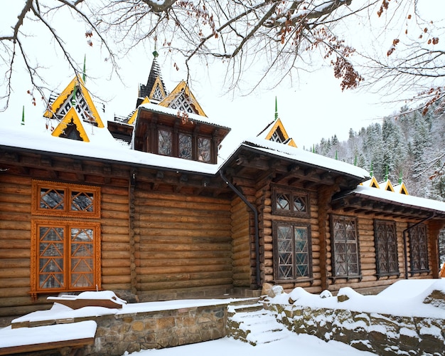 Country wooden house and winter forest behind (Carpathian, Ukraine)