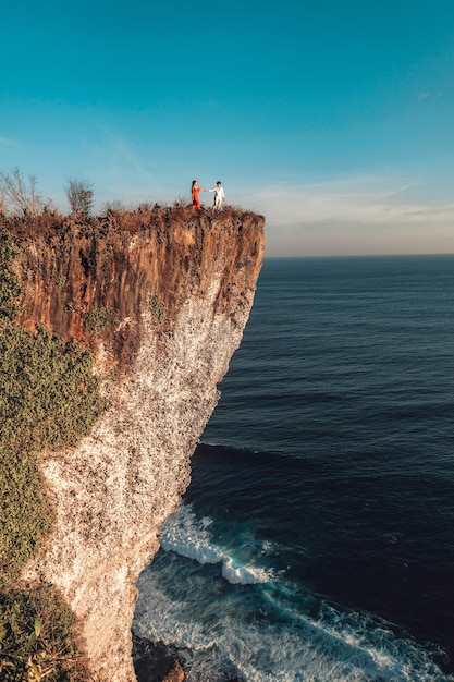 Couple Adventure and looking view on the karang boma cliff at Uluwatu Bali in Indonesia