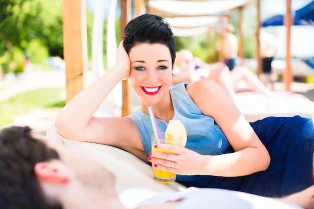 Couple in beach bar relaxing with drinks