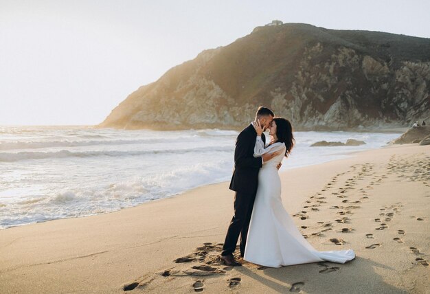 Photo a couple on the beach with footprints in the sand