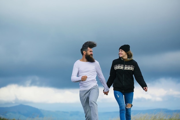 Couple bouncing on gray sky