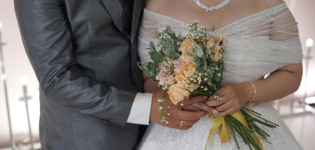 A Couple of Bride and Groom Holding a Flower Bucket in Wedding Ceremony