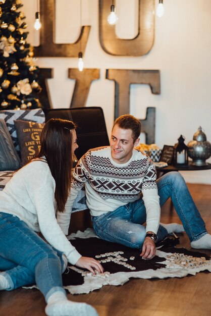 Couple celebrating Christmas and playing in a warm atmosphere at home