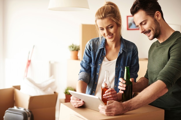 Couple chilling with beers and digital tablet