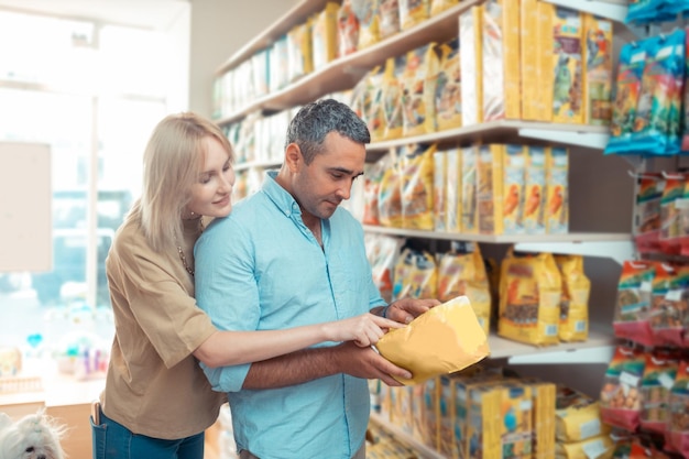 Couple choosing food for their cat while coming to pet shop