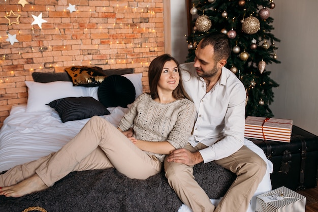 Couple on Christmas at home on bed near