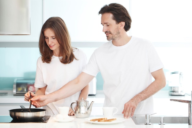 Couple cooking breakfast at kitchen