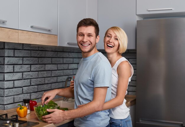 Photo couple cooking and looking at camera