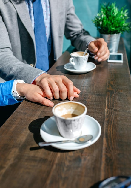 Couple of coworkers holding hands during coffee break