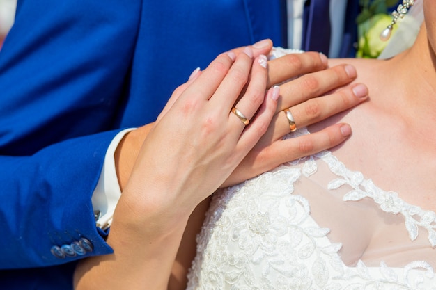 The couple cuddling and holding bridal bouquet.