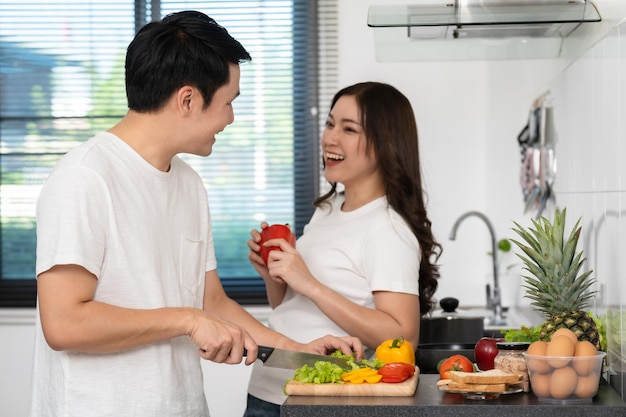 Couple cutting vegetables for preparing healthy food in the kitchen at home