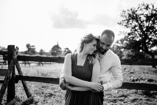 Couple on a date. Purple dress. Bride and groom. Walk in the field. Love story. Black and white photo.