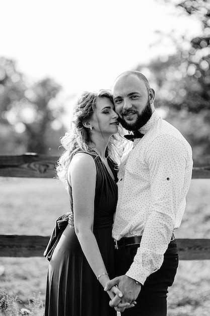 Couple on a date. Purple dress. Bride and groom. Walk in the field. Love story. Black and white photo.