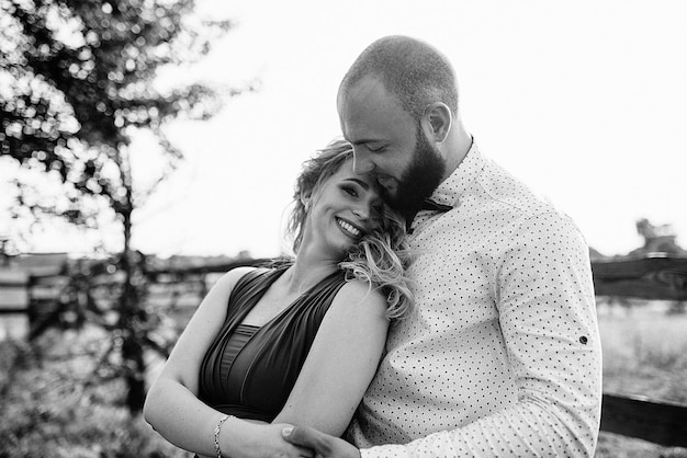 Couple on a date. Purple dress. Bride and groom. Walk in the field. Love story. Black and white photo.