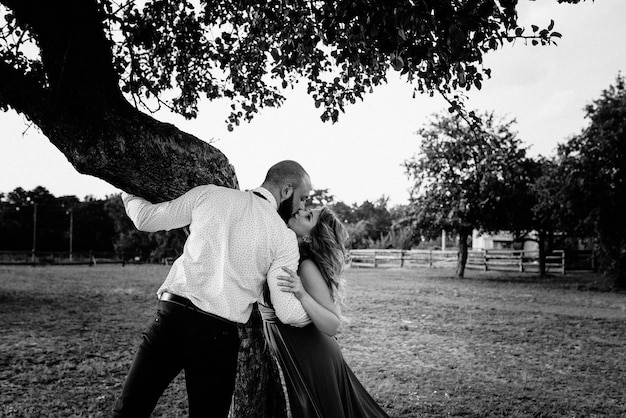 Couple on a date. Purple dress. Bride and groom. Walk in the field. Love story. Black and white photo.