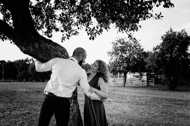 Couple on a date. Purple dress. Bride and groom. Walk in the field. Love story. Black and white photo.