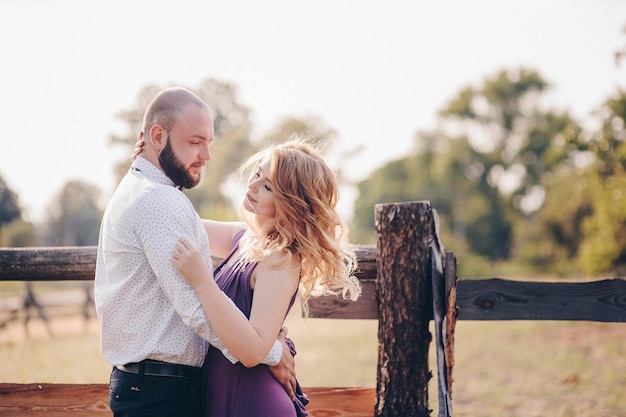 Couple on a date. Purple dress. Bride and groom. Walk in the field. Love story.