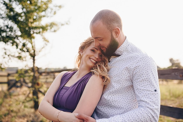 Couple on a date. Purple dress. Bride and groom. Walk in the field. Love story.