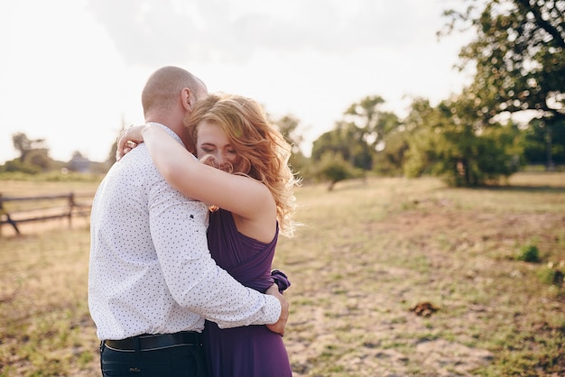 Couple on a date. Purple dress. Bride and groom. Walk in the field. Love story.