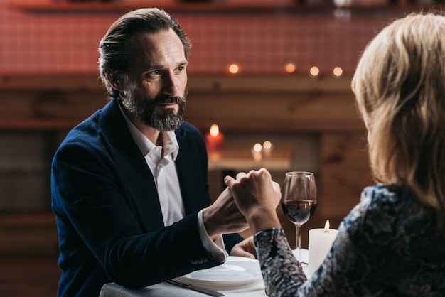 Couple dining at a restaurant holding hands