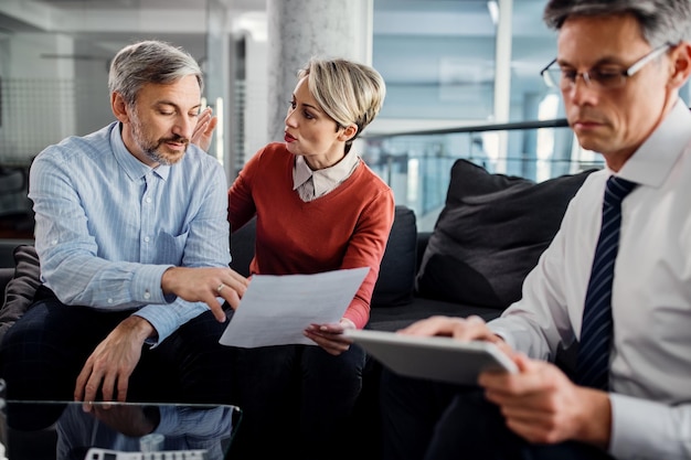 Couple discussing about an agreement while having a meeting with insurance agent in the office