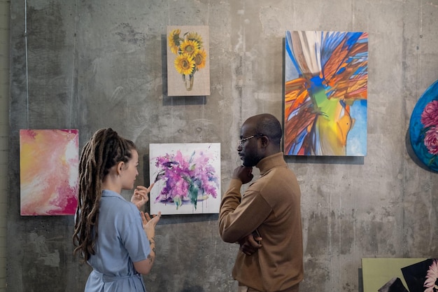 Couple discussing modern art in studio