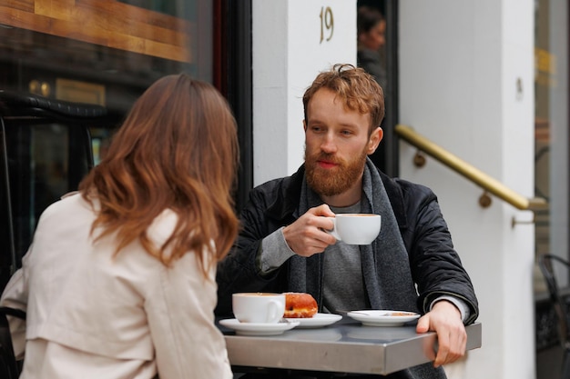 Couple drinking coffee and laughing talking to each other