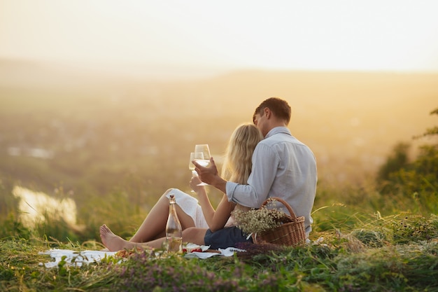 Couple drinking wine at a picnic in a field