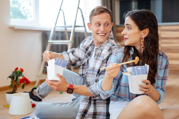 Couple eating noodles and planning their day in new apartment