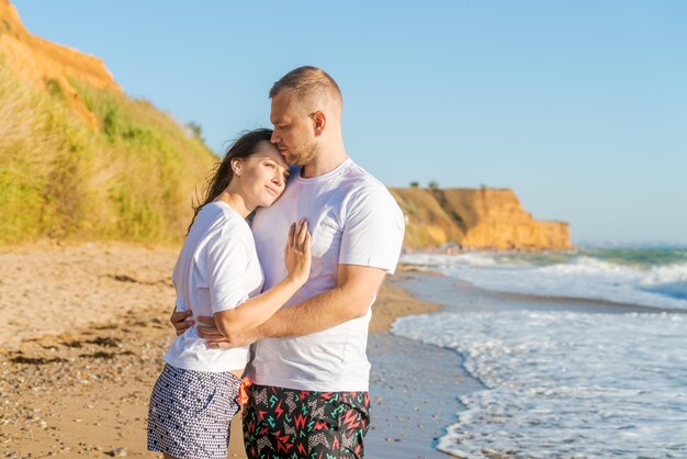 Couple embrace on the beach.