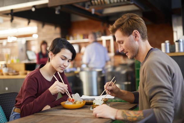 Couple Enjoying Asian Food in Cafe