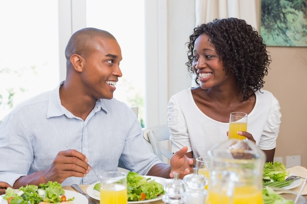 Couple enjoying a healthy meal together smiling at each other