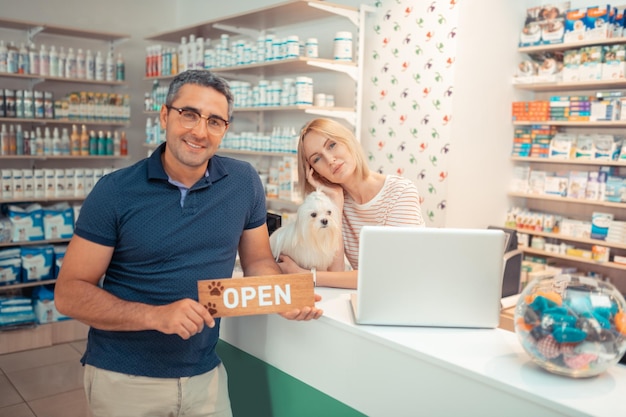 Couple of entrepreneurs greeting customers after opening pet shop