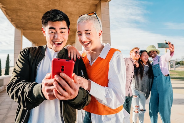 Couple or friends watching and having fun with a smart phone