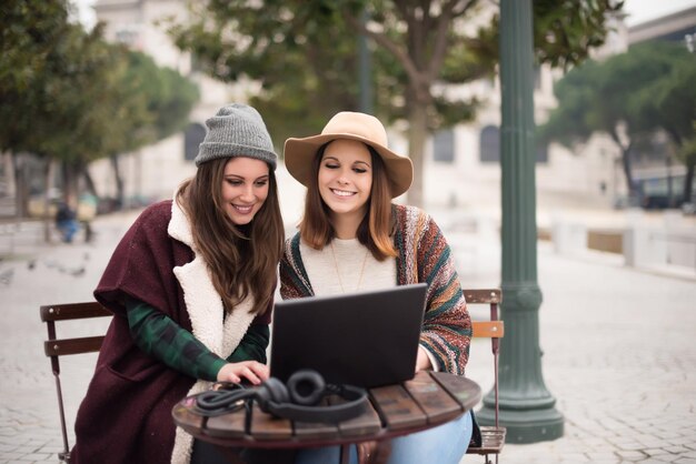 Couple of girls watching funny videos on a laptop