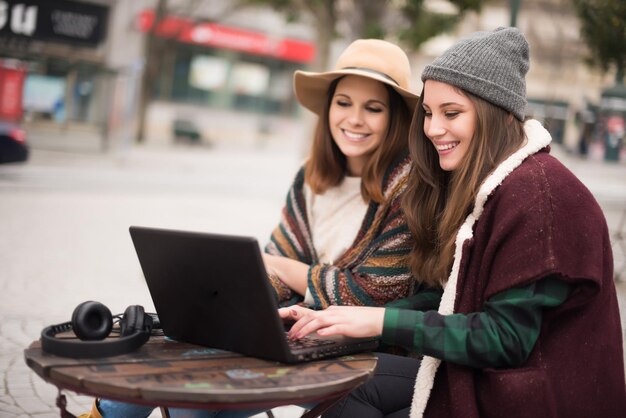 Couple of girls watching funny videos on a laptop