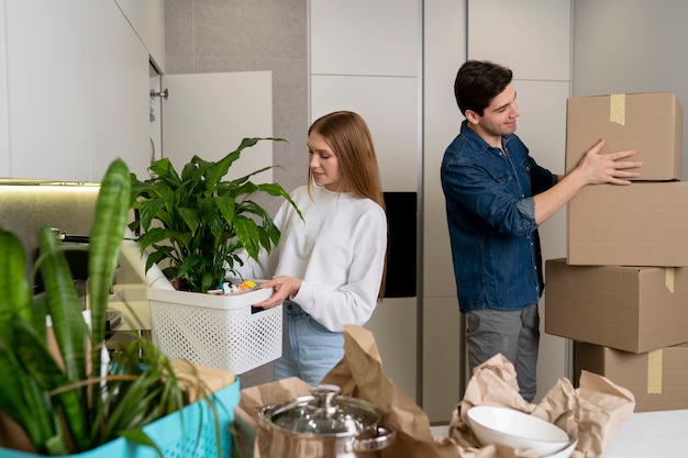 Couple handling boxes of belongings after moving in a new house