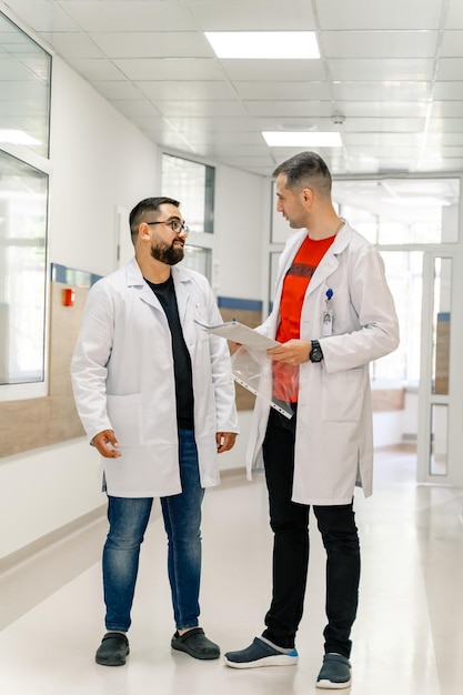 Couple of handsome doctors discussing something. Medical professional teamwork in hospital.