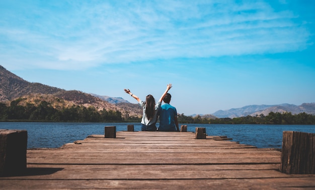 couple happy and relaxed sitting on a pier