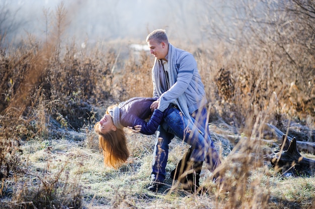 Couple has fun and laughs. kiss. Young hipster couple hugging each other in winter park. Winter love story, a beautiful stylish young couple. Winter fashion concept with boyfriend and girlfriend.