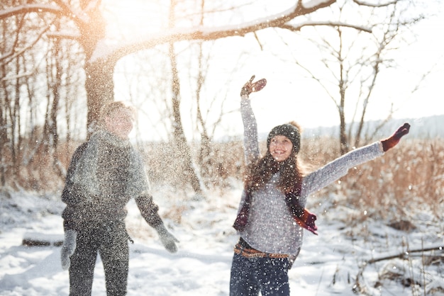 Couple has fun and laughs. kiss. Young hipster couple hugging each other in winter park. Winter love story, a beautiful stylish young couple. Winter fashion  with boyfriend and girlfriend