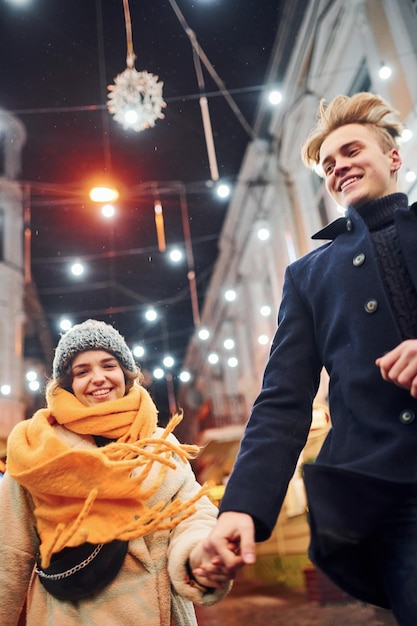 Couple have a walk together on the christmas decorated street.