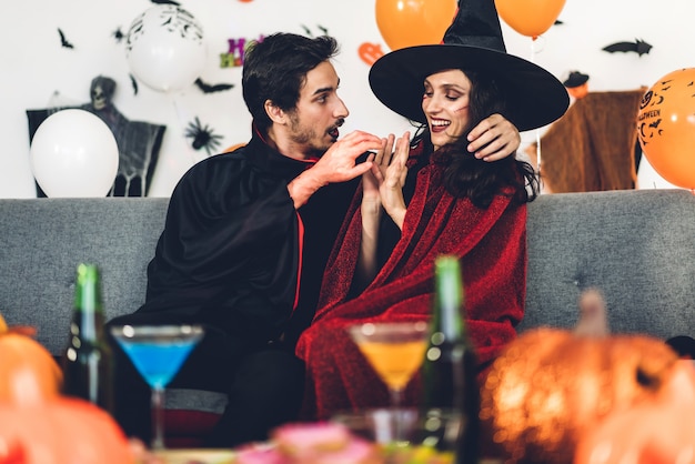 Couple having fun holding pumpkins and wearing dressed carnival halloween costumes