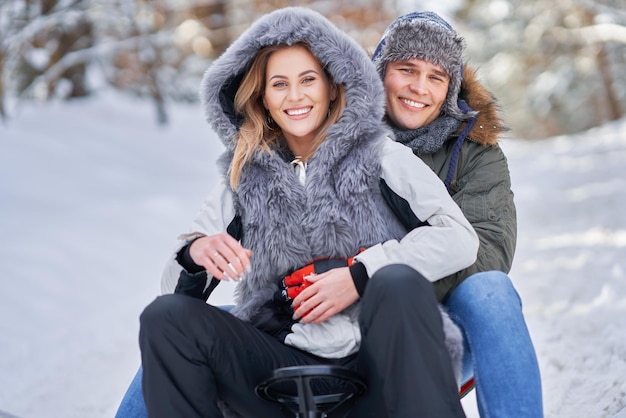 Couple having fun with sledge on snow in winter snow. High quality photo