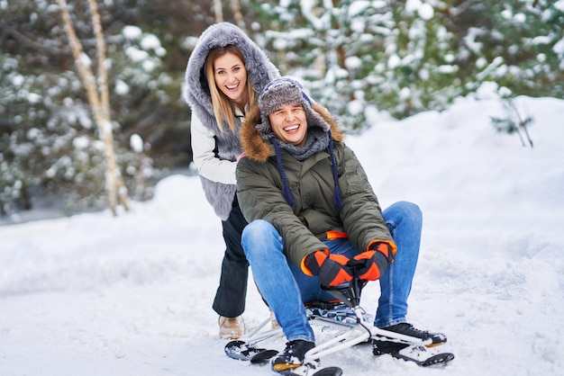 Couple having fun with sledge on snow in winter snow. High quality photo