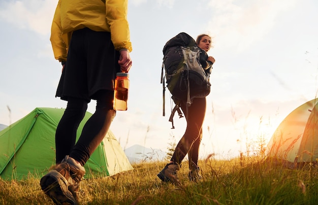 Couple having a walk outdoors near green tent Conception of traveling