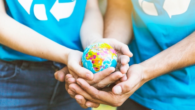 Couple holding globe in hands together