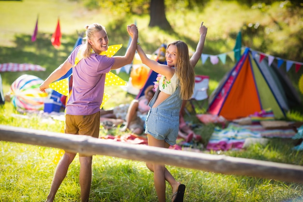 Couple holding hands and walking near campsite