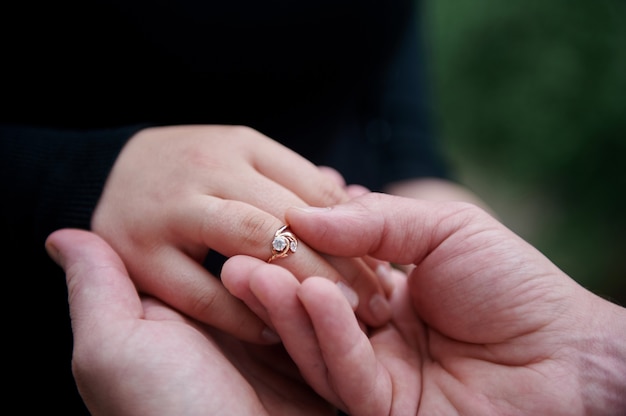 Couple holding hands with diamond ring