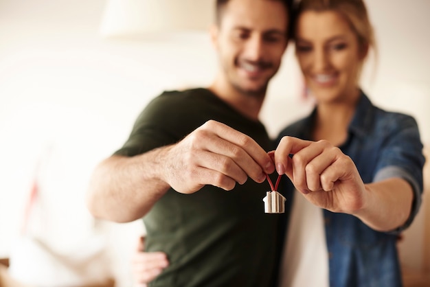 Couple holding key ring to their new house